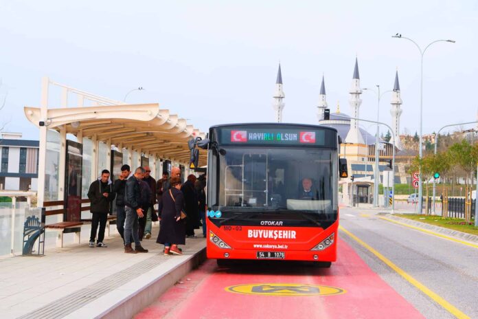 Metrobüs durağında yolcular bekliyor, ek seferler ile ulaşım kolaylaşıyor.